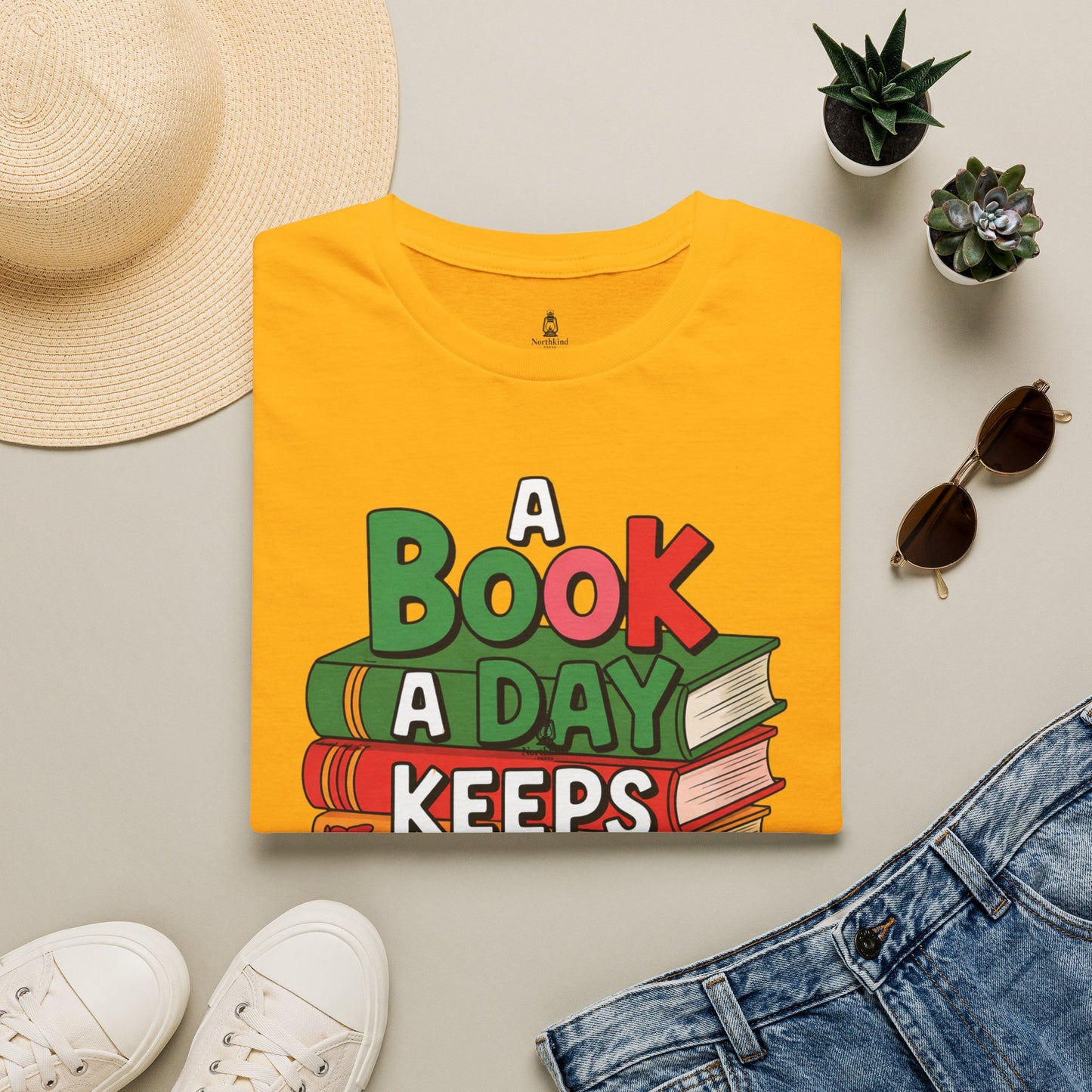 'A Book a Day Keeps Reality Away' T-Shirt — Stack of Books Graphic