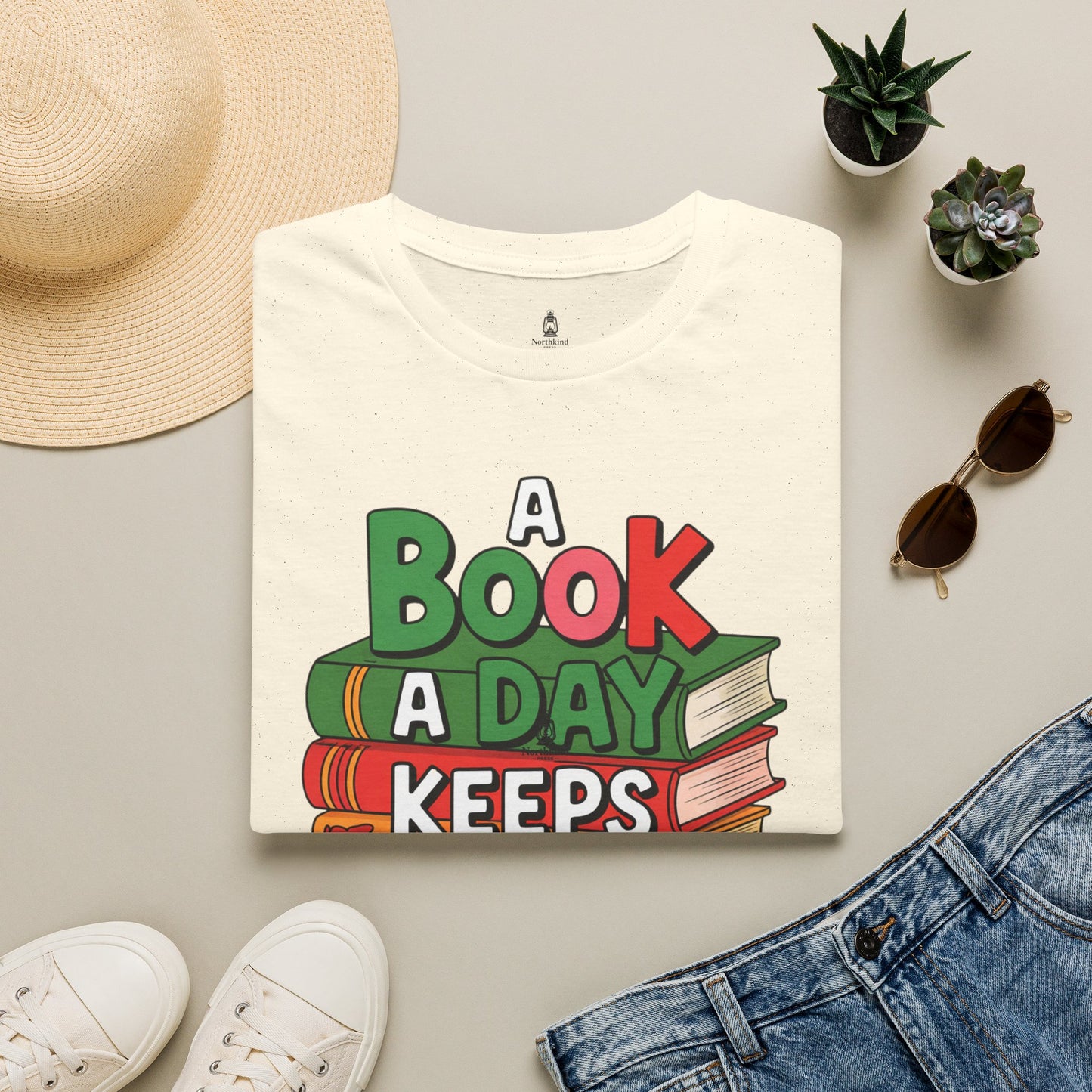 'A Book a Day Keeps Reality Away' T-Shirt — Stack of Books Graphic